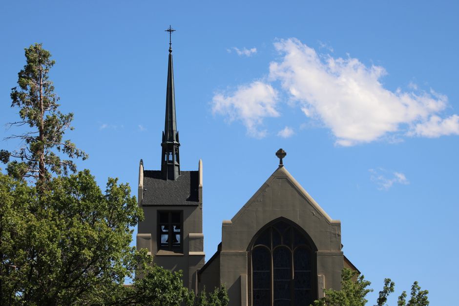 A Gothic-style church steeple rises against a clear blue sky in Reno, Nevada.